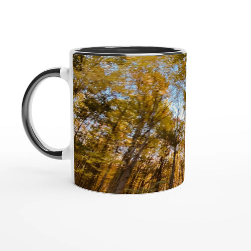 Ceramic mug with sunlit autumn forest artwork and black handle
