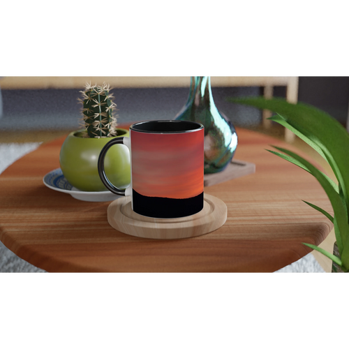 ceramic mug featuring mountain sunrise on a wooden table with plants