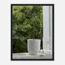 Black thin frame canvas art of incense vessel on porch overlooking woods