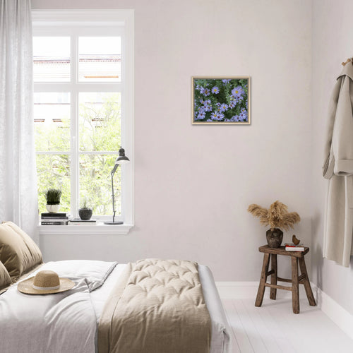Lilac aster blooms framed canvas art displayed in a softly lit modern bedroom