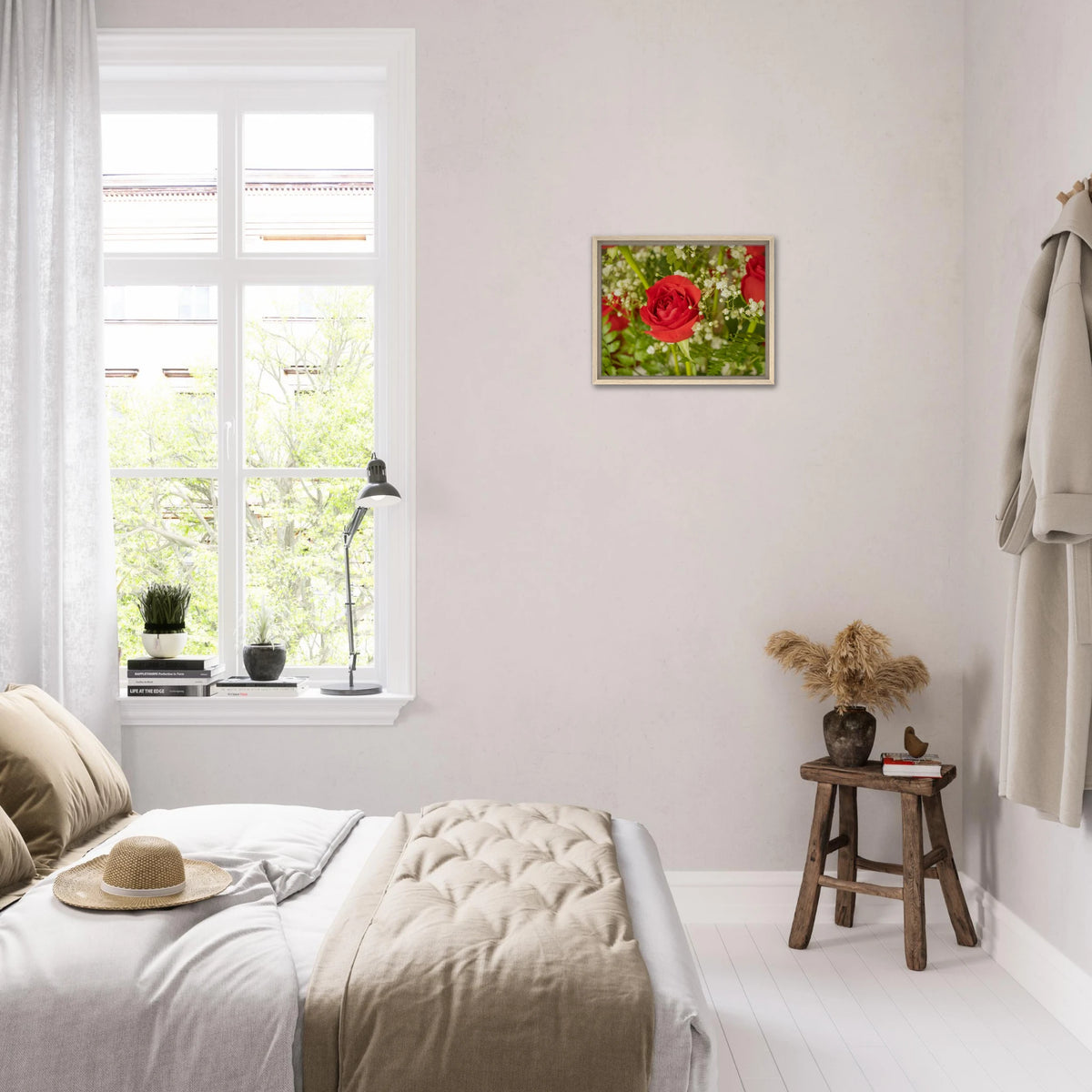 Bedroom interior with a framed canvas print of a red rose and baby's breath on the wall above a rustic wooden stool