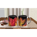Two ceramic mugs with black interiors displaying autumn leaves on a dining table